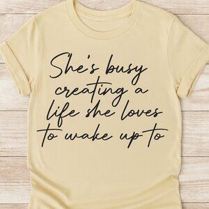 ✨ “She’s Busy Creating a Life She Loves” Inspirational Tee – Beige | Women’s Mot